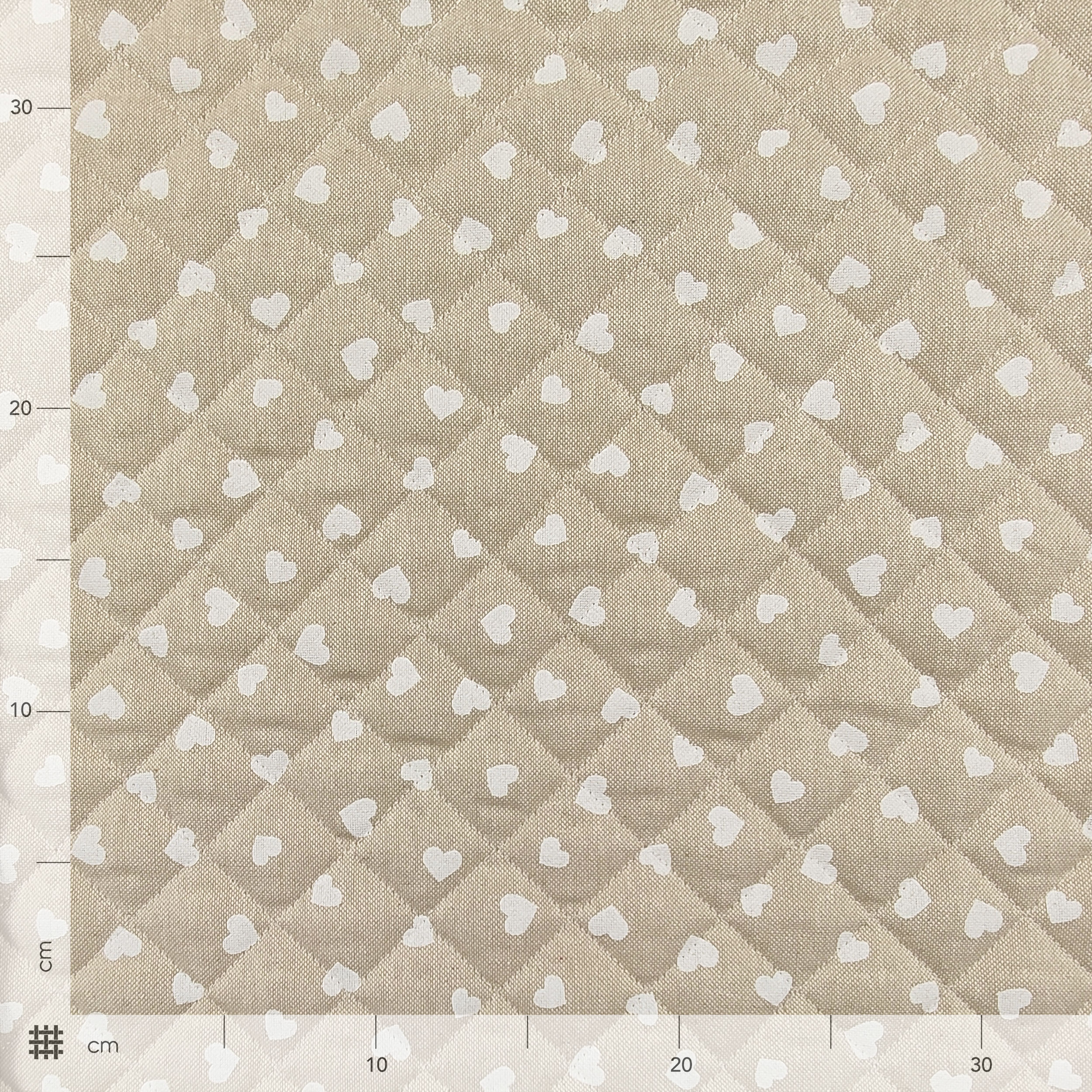 Tessuto Trapuntato con Cuori Bianchi Sfondo Beige Image